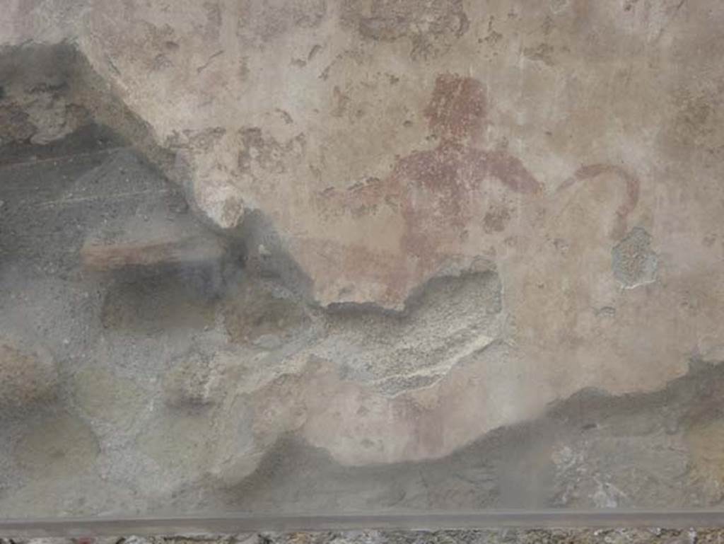 IV.17, Herculaneum, October 2015. Detail of the Priapus figure painted on the wall behind the sales counter. Photo courtesy of Michael Binns.